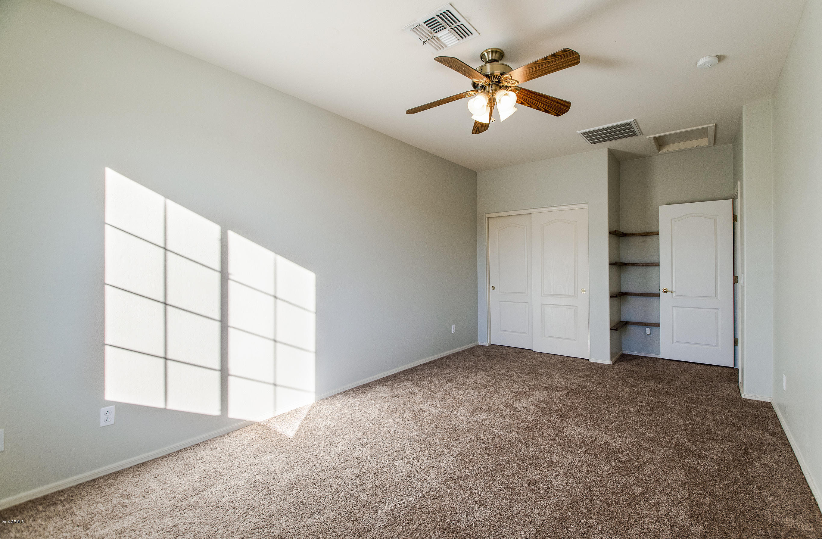 3236 East Phelps Street Gilbert, AZ 85295 - Photo 18 of 29 an empty room with windows and ceiling fan