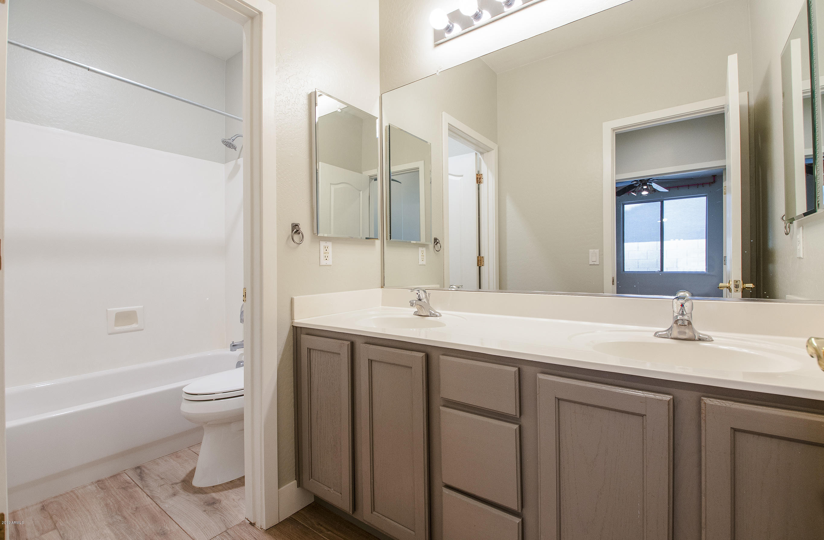3236 East Phelps Street Gilbert, AZ 85295 - Photo 23 of 29 a bathroom with a granite countertop sink a toilet and a large mirror