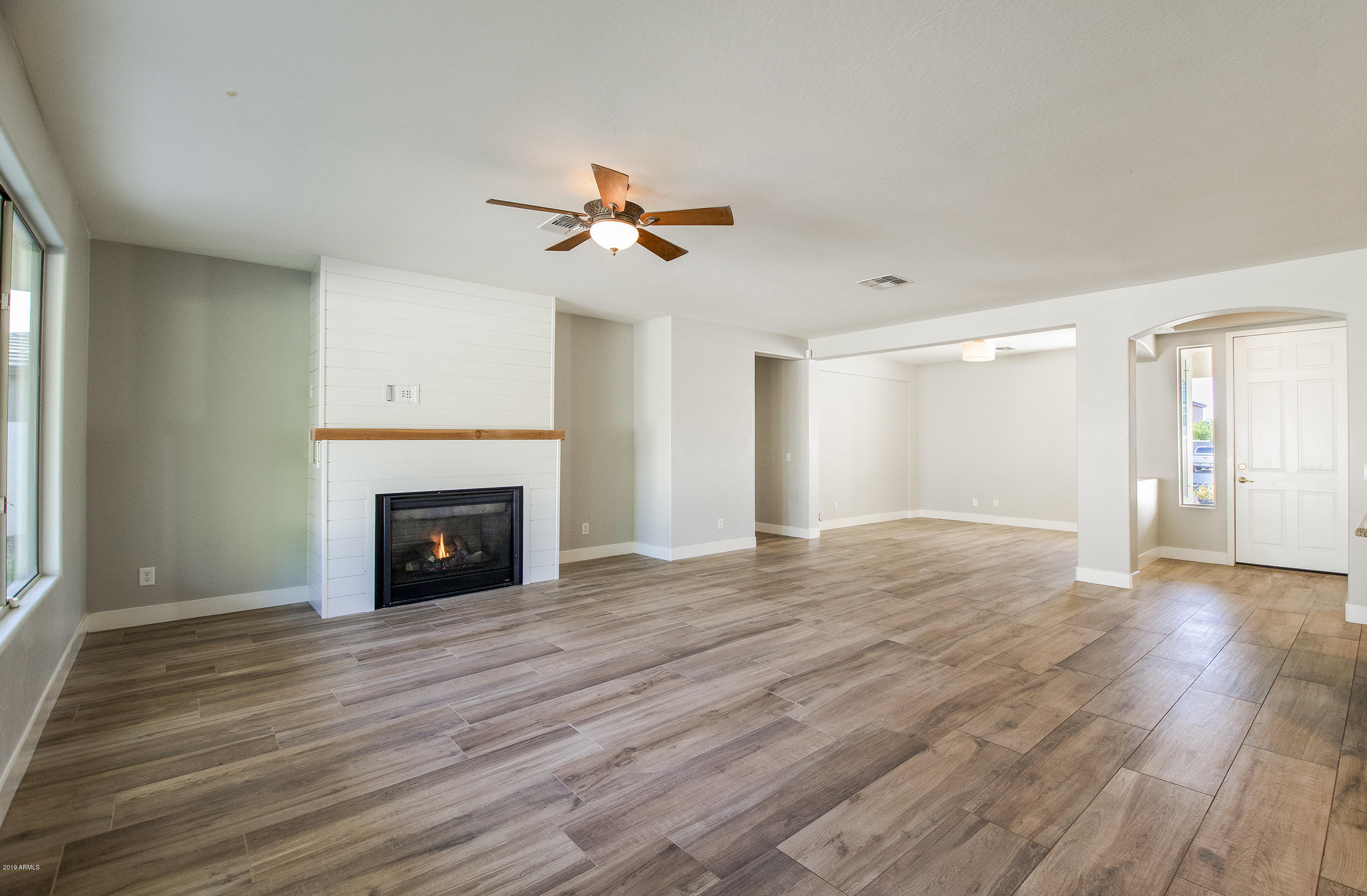 3236 East Phelps Street Gilbert, AZ 85295 - Photo 3 of 29 a view of empty room with wooden floor and fireplace