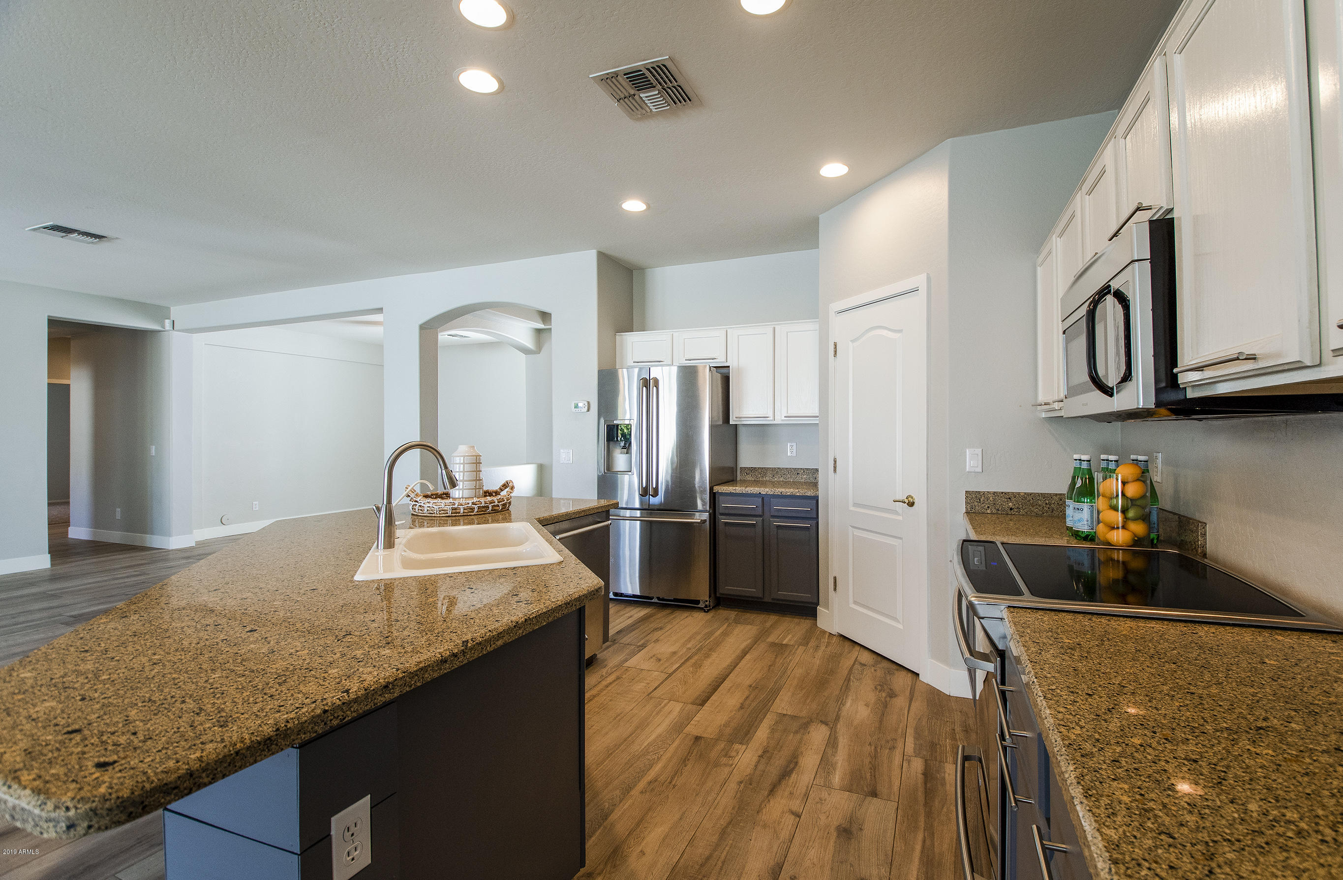 3236 East Phelps Street Gilbert, AZ 85295 - Photo 5 of 29 a kitchen with stainless steel appliances granite countertop a sink refrigerator and cabinets