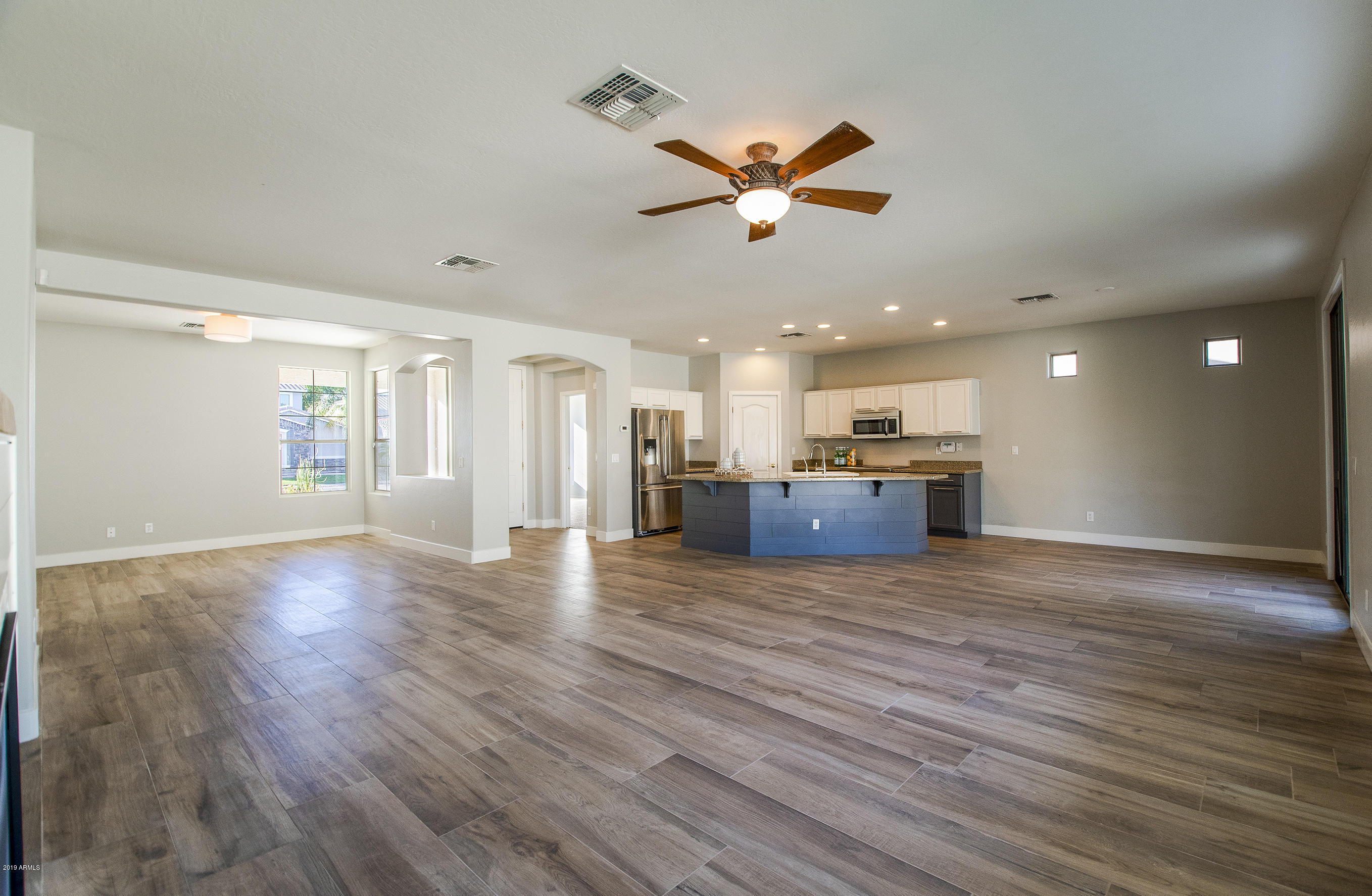 3236 East Phelps Street Gilbert, AZ 85295 - Photo 7 of 29 a view of an empty room and kitchen with wooden floor