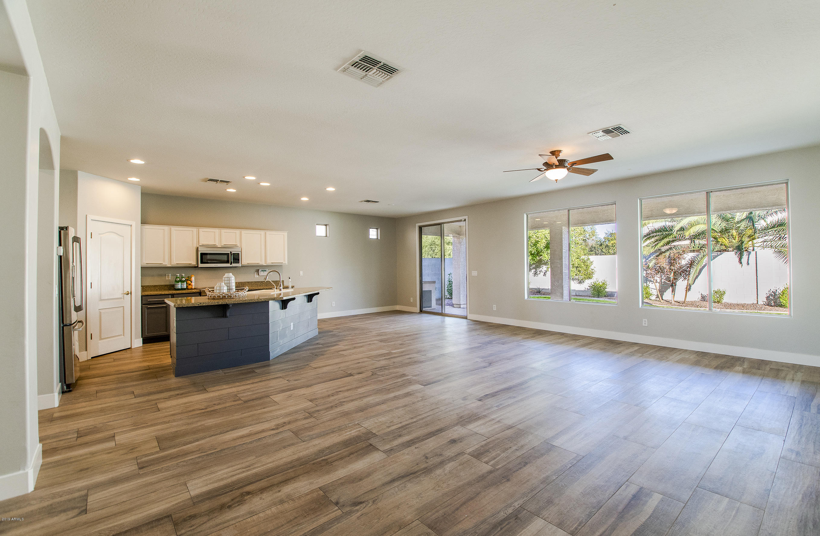 3236 East Phelps Street Gilbert, AZ 85295 - Photo 8 of 29 a large kitchen with stainless steel appliances kitchen island a large counter top and a wooden floors