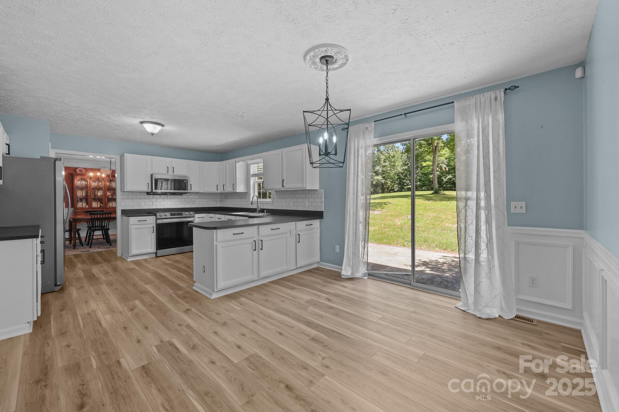 25611 Bridgeport Road Albemarle, NC 28001 - Photo 14 of 47 a large kitchen with stainless steel appliances granite countertop a stove and a wooden floors