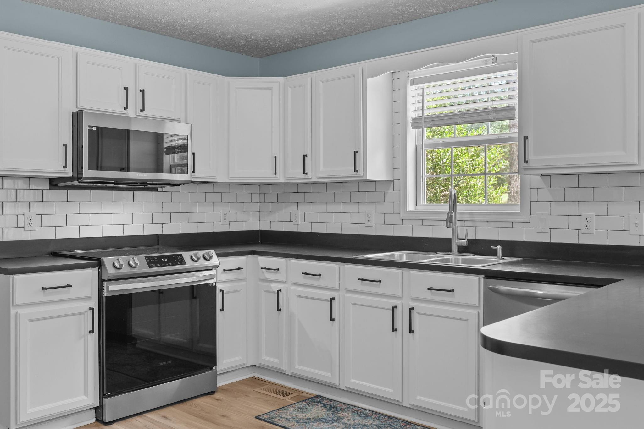 25611 Bridgeport Road Albemarle, NC 28001 - Photo 15 of 47 a kitchen with white cabinets stainless steel appliances and sink