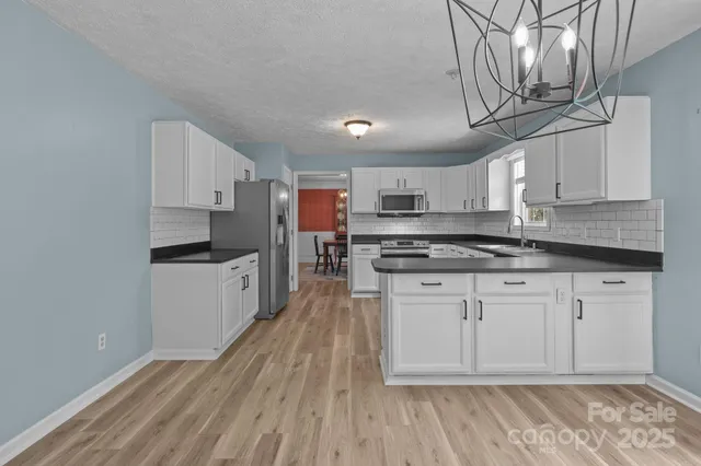a kitchen with granite countertop white cabinets sink and window