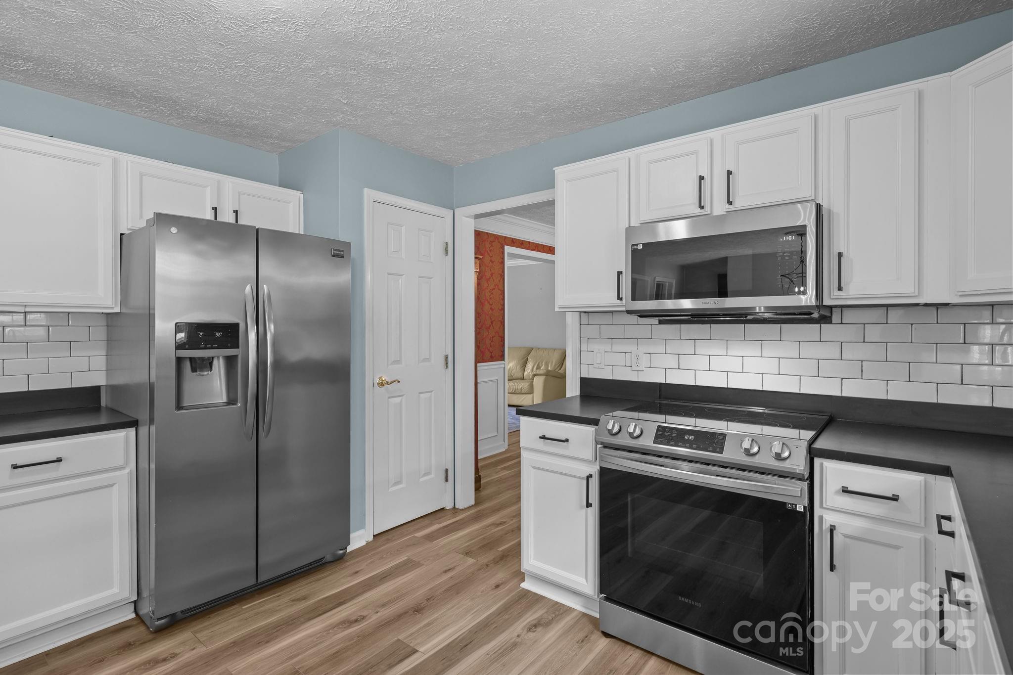 25611 Bridgeport Road Albemarle, NC 28001 - Photo 18 of 47 a kitchen with cabinets stainless steel appliances and a wooden floor