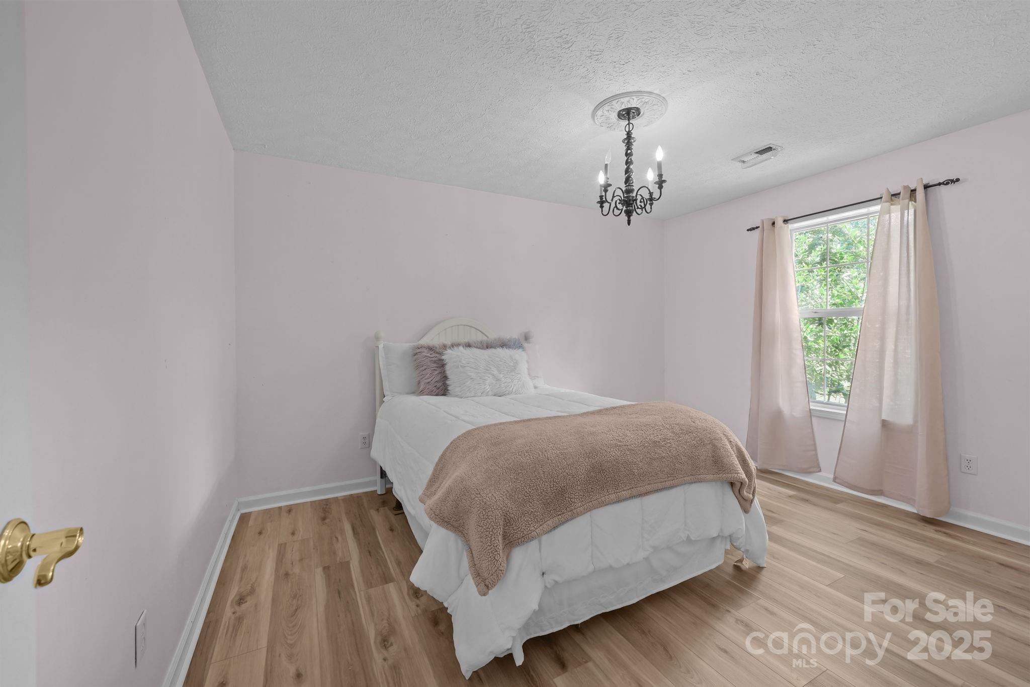 25611 Bridgeport Road Albemarle, NC 28001 - Photo 34 of 47 a bedroom with a bed and wooden floor