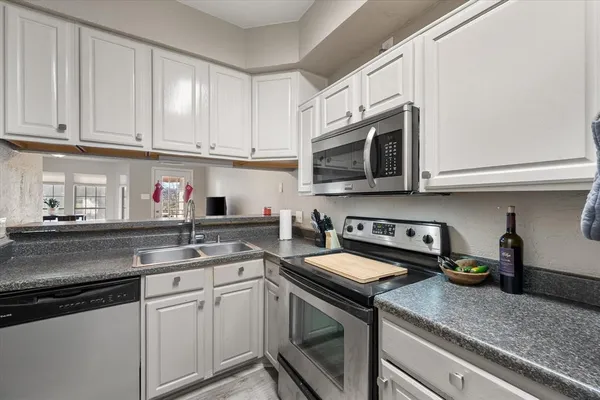 a kitchen with stainless steel appliances granite countertop a sink a stove a microwave and cabinets