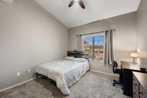 a bedroom with a bed and a lamp next to a window