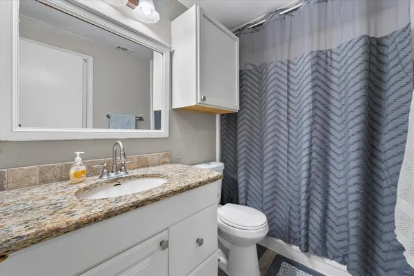 a bathroom with a granite countertop sink and a mirror