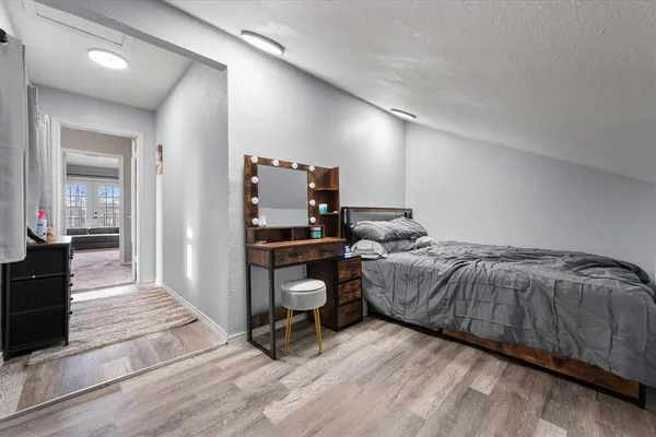 a bedroom with a bed and wooden floor