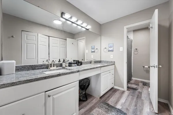 a bathroom with a sink double vanity granite and a mirror