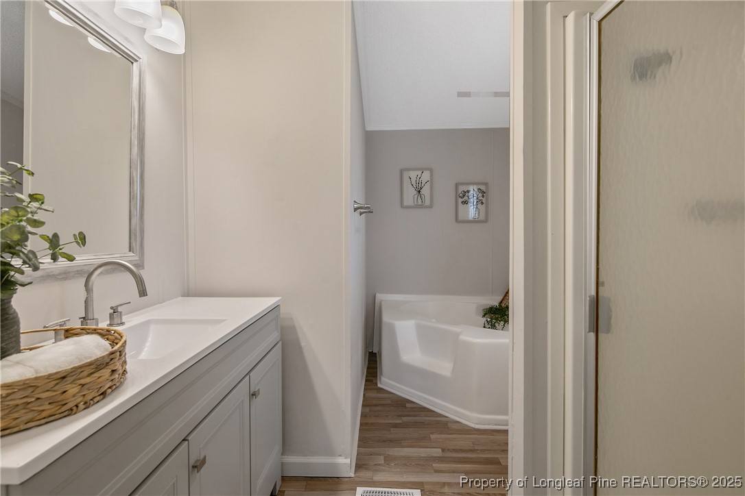 43 Columbus Court Spring Lake, NC 28390 - Photo 17 of 22 a bathroom with a granite countertop sink toilet and shower