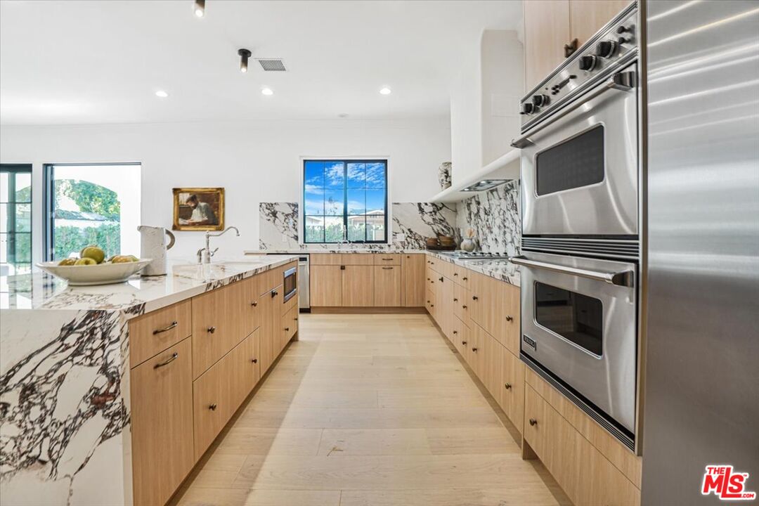 5717 Topeka Drive Tarzana, CA 91356 - Photo 18 of 52 a large white kitchen with a stove a sink and a refrigerator