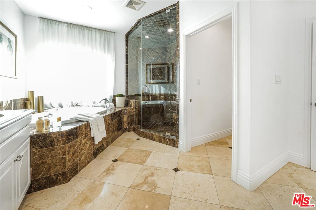 5717 Topeka Drive Tarzana, CA 91356 - Photo 36 of 52 a en suite bathroom with a tub sink and mirror