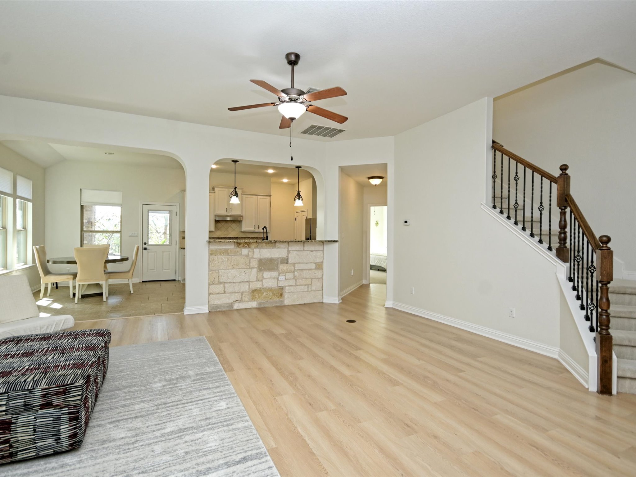 201 Bellagio Drive Austin, TX 78734 - Photo 31 of 31 Open floor plan living makes it easy to stay connected, while the kitchen connects seamlessly through an arched opening with bar seating and pendant lighting.