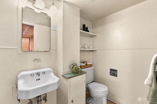 a bathroom with a sink a toilet and a mirror