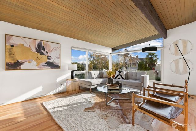 a living room with furniture a rug and a large window