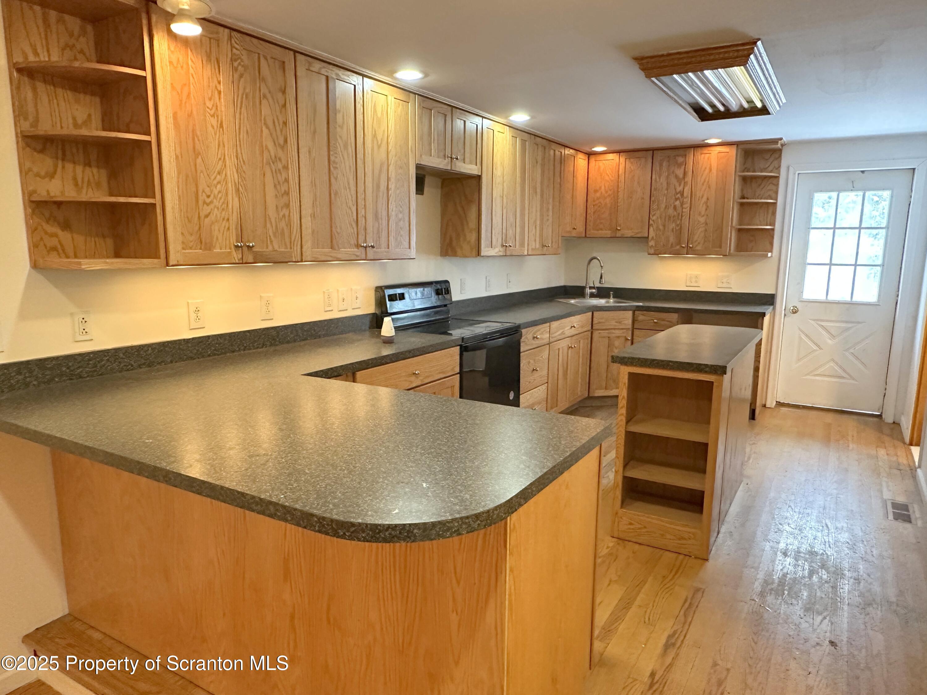 534 2nd Avenue Jessup, PA 18434 - Photo 4 of 14 a kitchen with stainless steel appliances granite countertop a sink a stove and a microwave oven with wooden floor