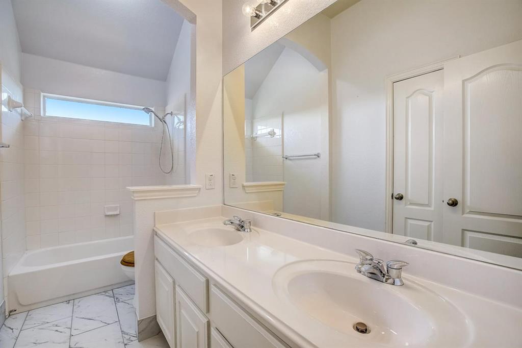 3604 Rams Horn Way Round Rock, TX 78665 - Photo 18 of 26 Double vanity and a tiled shower-tub combo create a bright, functional bath space.