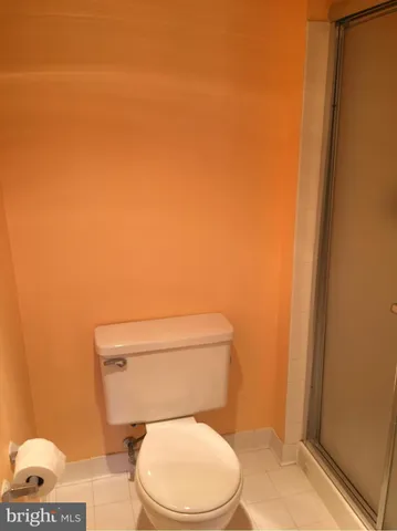 a white toilet sitting next to a shower