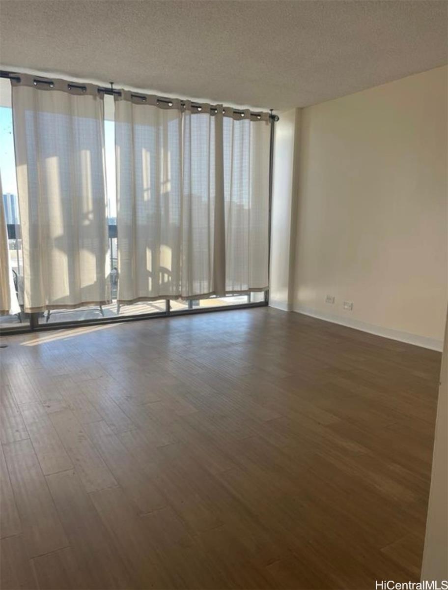 1560 Thurston Avenue, Unit 502 Honolulu, HI 96822 - Photo 2 of 9 a view of an empty room with wooden floor and a window