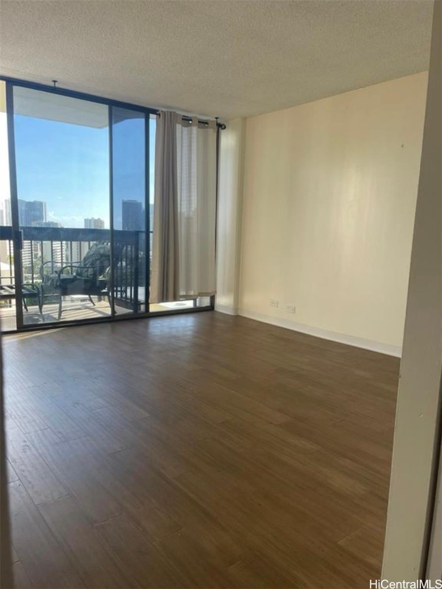 1560 Thurston Avenue, Unit 502 Honolulu, HI 96822 - Photo 3 of 9 an empty room with wooden floor and windows