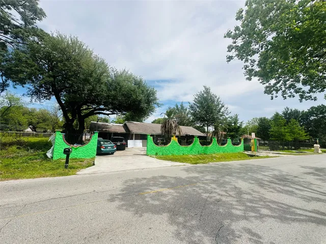 a view of a house with backyard and trees