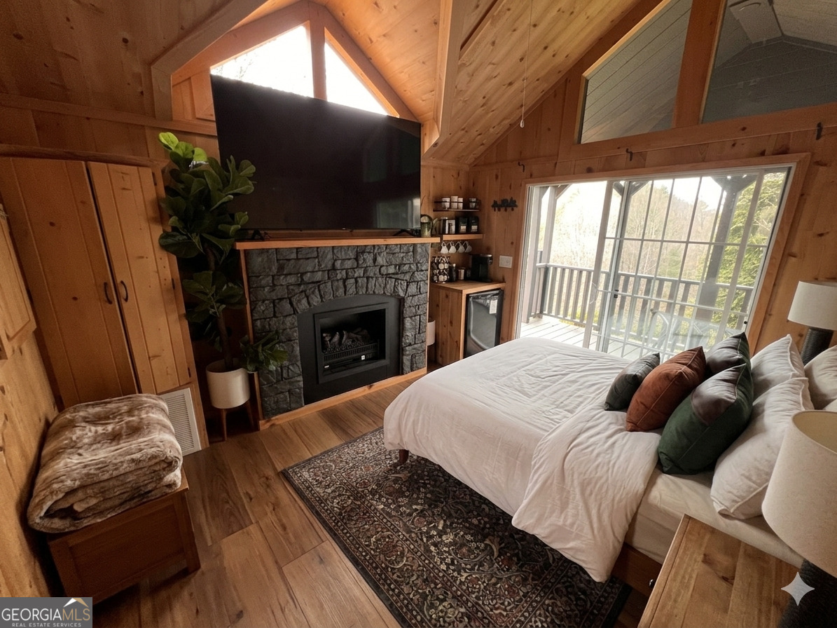 162 Dryman Ridge Road Scaly Mountain, NC 28775 - Photo 27 of 32 a bedroom with a bed and a fireplace