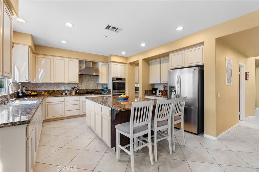 1137 Pamplona Drive Riverside, CA 92508 - Photo 16 of 50 a white kitchen with stainless steel appliances granite countertop a refrigerator and a stove top oven