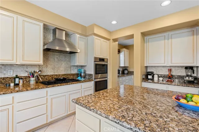 a kitchen with stainless steel appliances granite countertop a sink refrigerator and cabinets