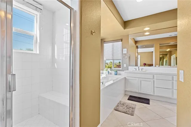 a bathroom with a sink mirror and a bathtub next to a window