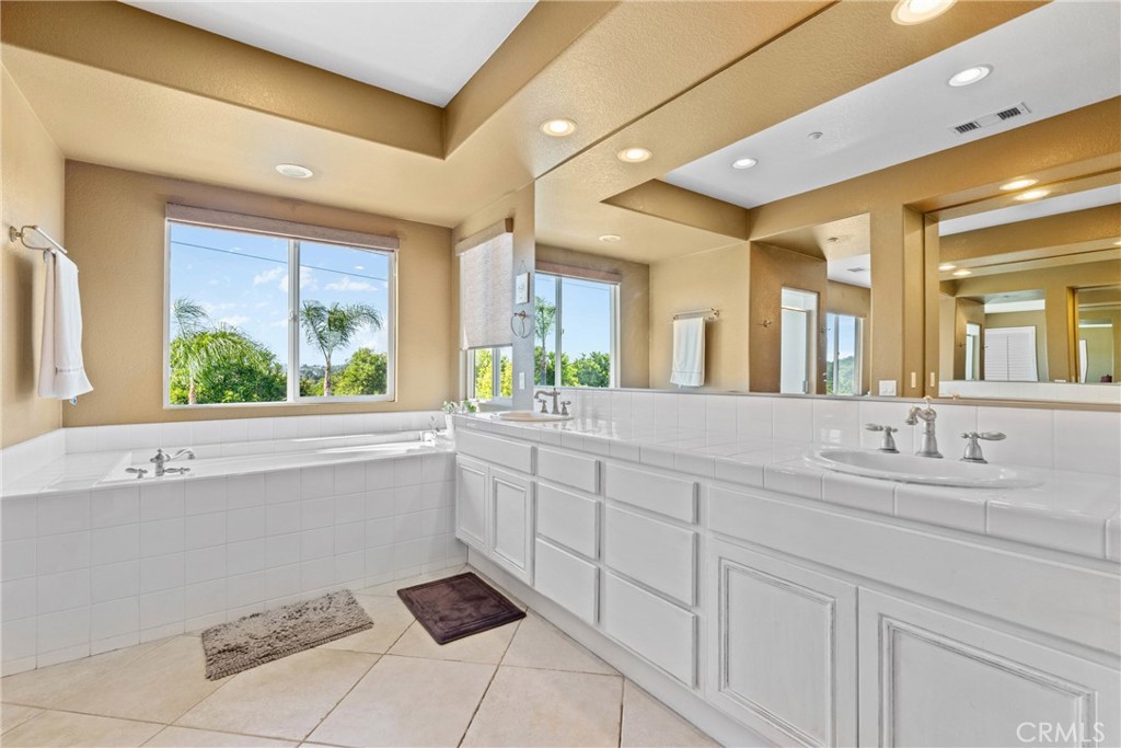 1137 Pamplona Drive Riverside, CA 92508 - Photo 32 of 50 a bathroom with a sink mirror and a bathtub next to a window