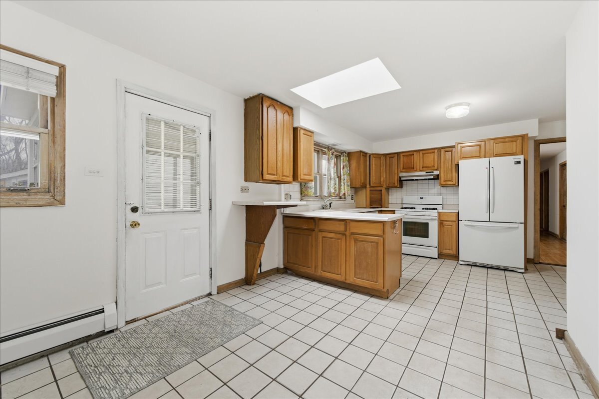6N879 Dunham Road Wayne, IL 60184 - Photo 11 of 27 a kitchen with a cabinets a sink a window and stainless steel appliances