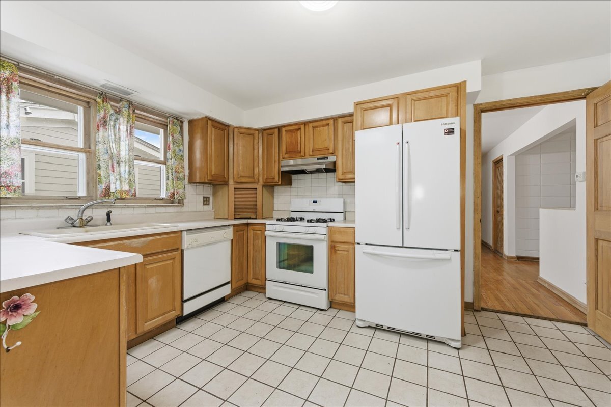 6N879 Dunham Road Wayne, IL 60184 - Photo 8 of 27 a kitchen with a stove a sink dishwasher a refrigerator and cabinets