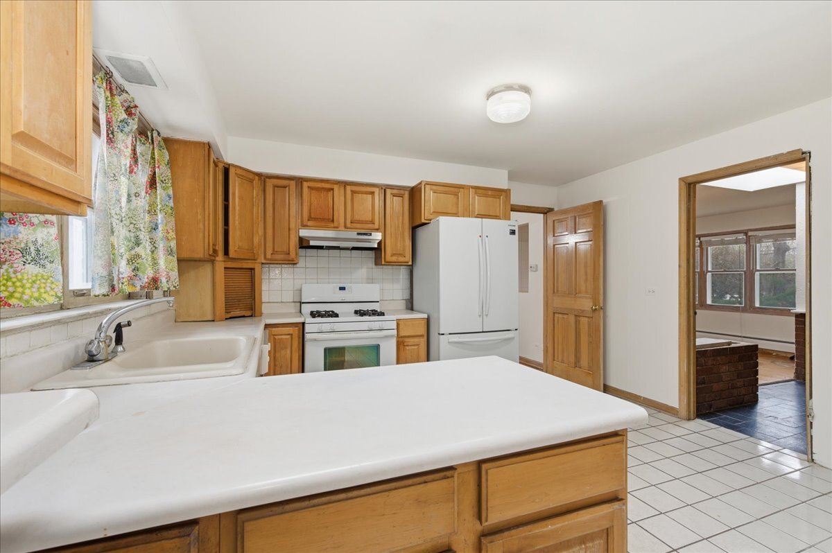 6N879 Dunham Road Wayne, IL 60184 - Photo 9 of 27 a kitchen with kitchen island a sink a stove and refrigerator