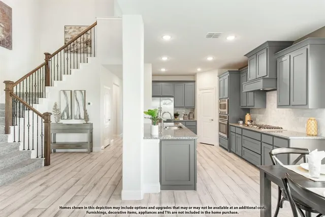 a large kitchen with kitchen island a large counter top stainless steel appliances and cabinets