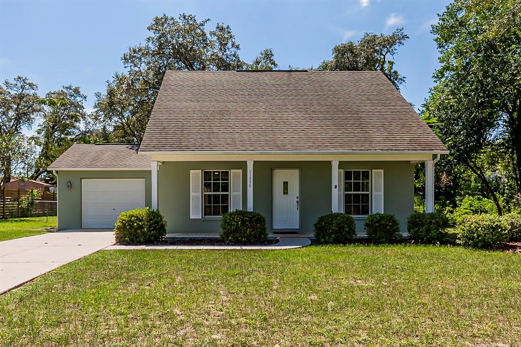 11350 Sheffield Road Spring Hill, FL 34608 - Photo 1 of 1 a front view of house with yard and trees
