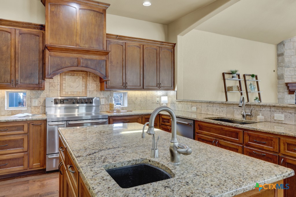 7607 Sky Loop Garden Ridge, TX 78266 - Photo 9 of 43 a kitchen with granite countertop a sink a counter and cabinets