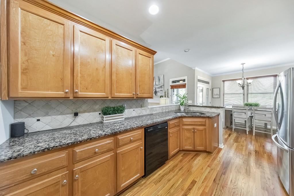 304 Turning Leaf Court Canton, GA 30115 - Photo 17 of 73 a kitchen with stainless steel appliances granite countertop a stove a sink and white cabinets with wooden floor
