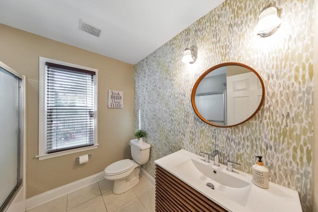 304 Turning Leaf Court Canton, GA 30115 - Photo 48 of 73 a bathroom with a sink a mirror a toilet and a window