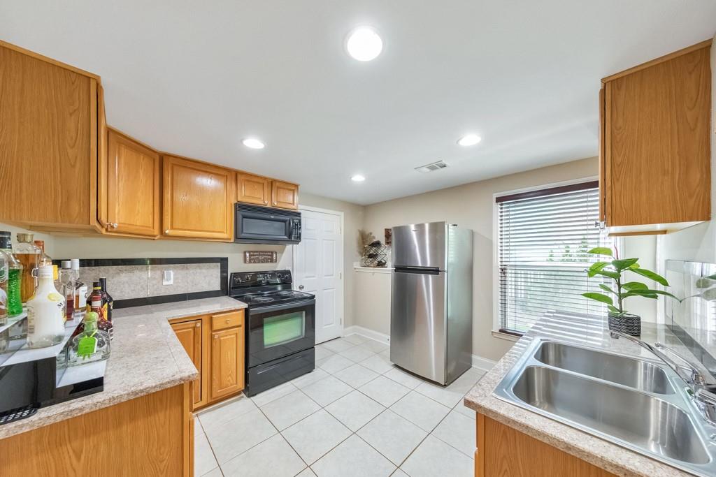 304 Turning Leaf Court Canton, GA 30115 - Photo 6 of 73 a kitchen with a sink a counter top space cabinets and stainless steel appliances