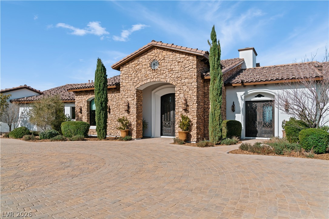 1123 Christian Road Henderson, NV 89002 - Photo 6 of 94 A Mediterranean-inspired dwelling welcomes with a stone facade and a paver driveway.