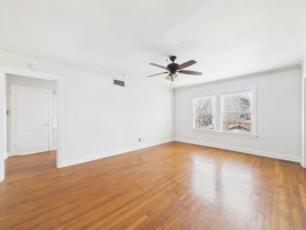 a view of empty room with wooden floor