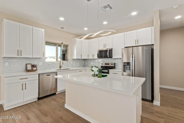 a kitchen with a refrigerator a white cabinets and wooden floor