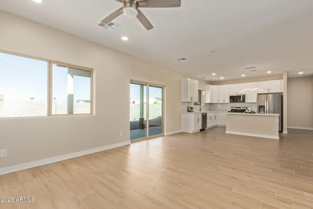 a view of a kitchen with kitchen island wooden floor center island and stainless steel appliances