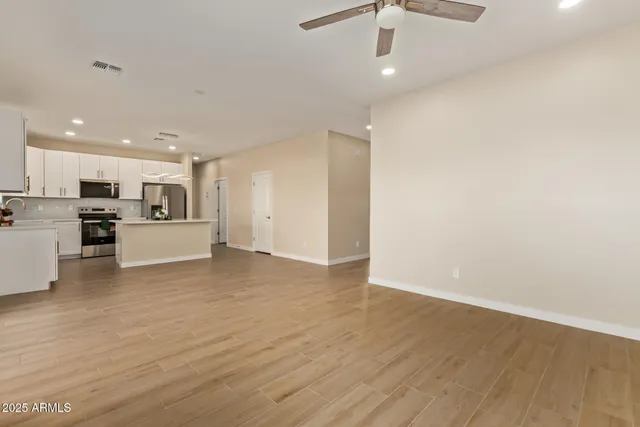 a view of a kitchen with a sink and dishwasher a refrigerator with wooden floor