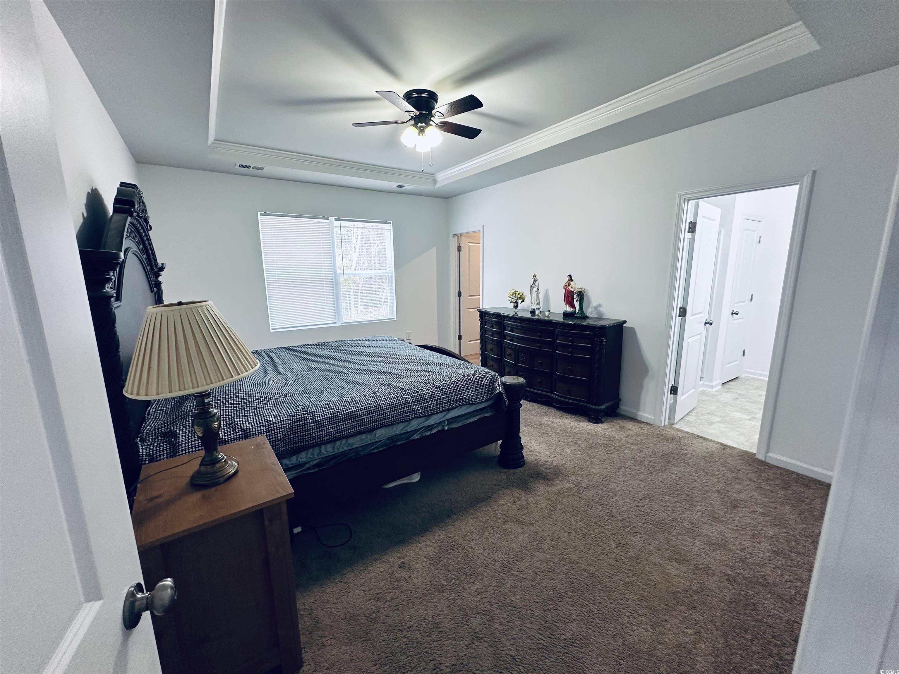 5260 Walnutwood Trail Myrtle Beach, SC 29579 - Photo 12 of 30 Carpeted bedroom featuring a tray ceiling, a ceiling fan, and crown molding