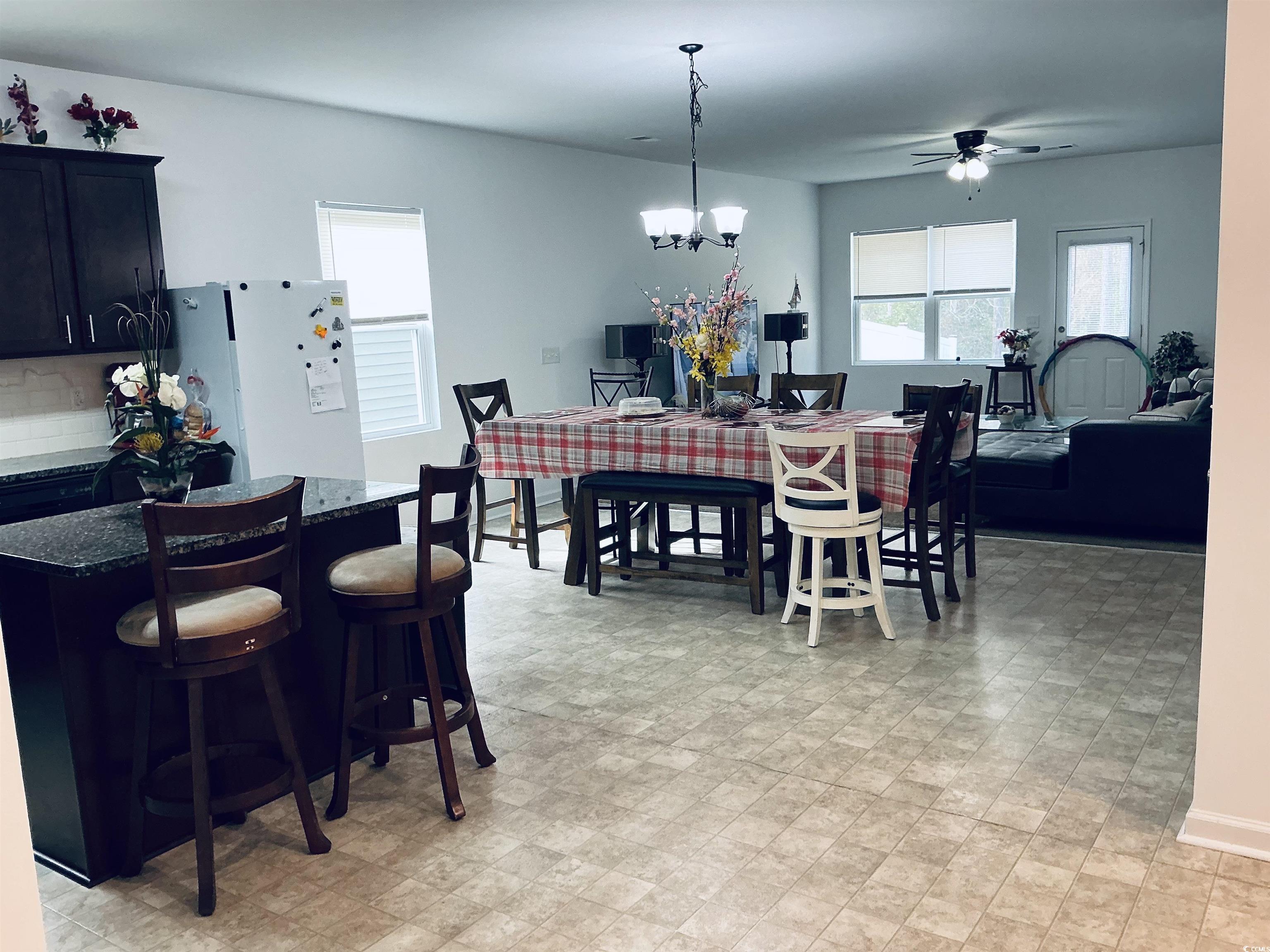 5260 Walnutwood Trail Myrtle Beach, SC 29579 - Photo 3 of 30 Dining area featuring healthy amount of natural light, a ceiling fan, a chandelier, and light floors