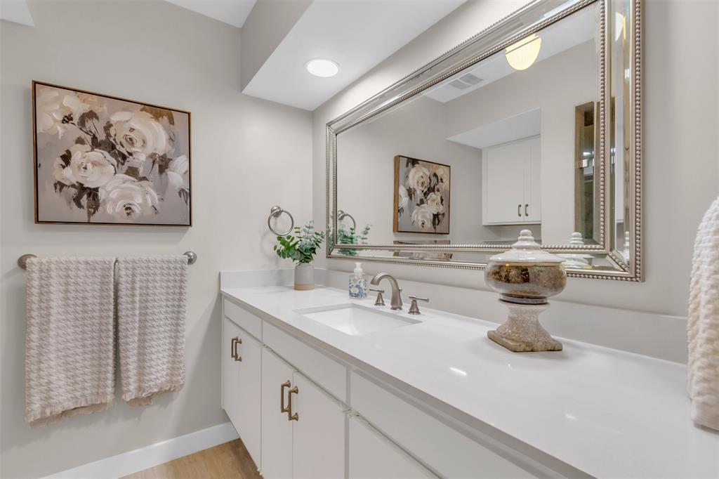 10763 Villager Road, Unit A Dallas, TX 75230 - Photo 11 of 21 a bathroom with a sink and a mirror